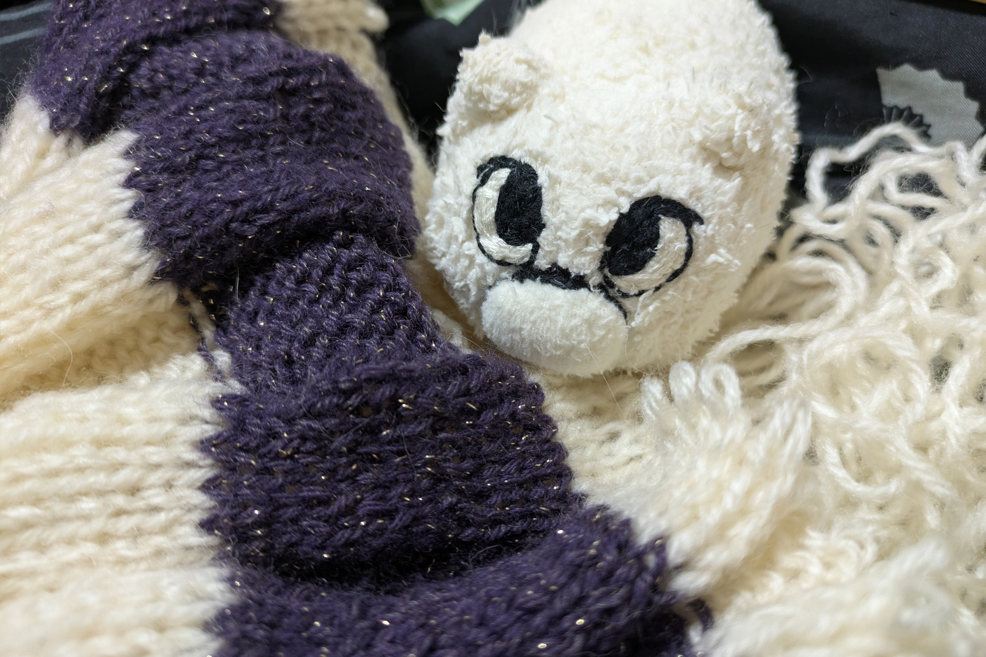 失敗した編み途中のマフラーを調べるマリー